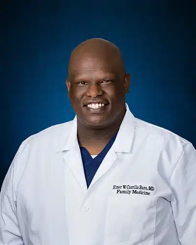 Professional headshot of Dr. Elmer Wilfredo Carrillo Baro, MD, wearing a white coat, smiling.